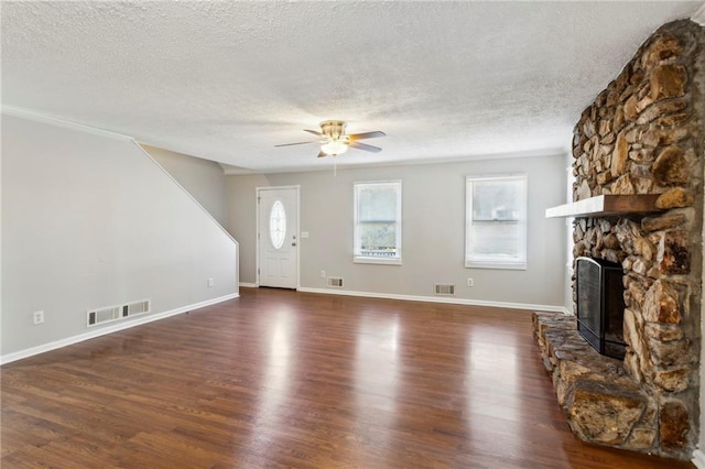 unfurnished living room featuring a wealth of natural light, a fireplace, and dark hardwood / wood-style floors