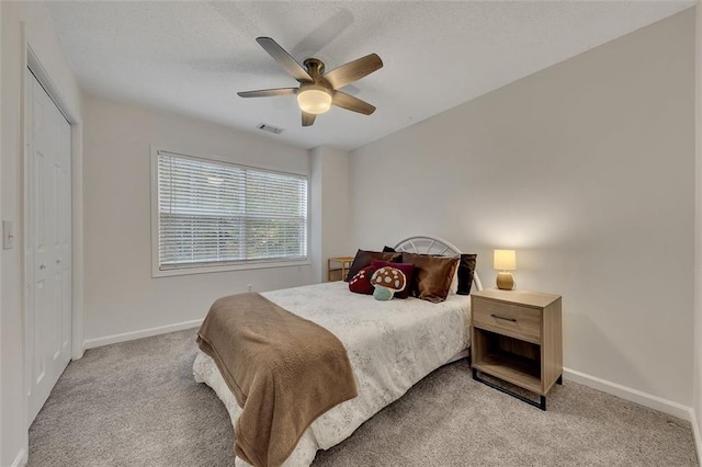 carpeted bedroom with ceiling fan and a closet