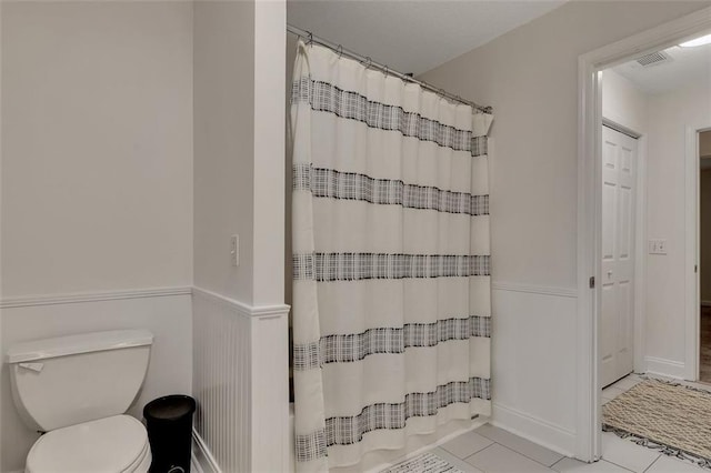 bathroom with toilet, tile patterned flooring, and a shower with shower curtain