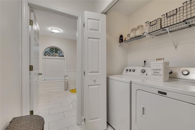 laundry room with washing machine and dryer and light tile patterned floors