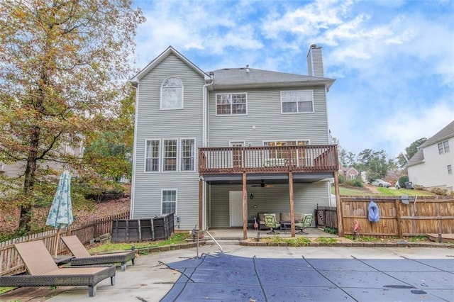 rear view of house with a covered pool, a patio area, and ceiling fan