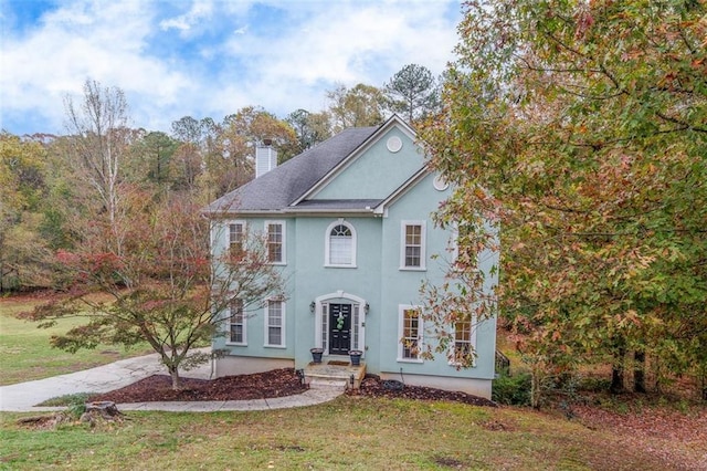 colonial home featuring a front lawn