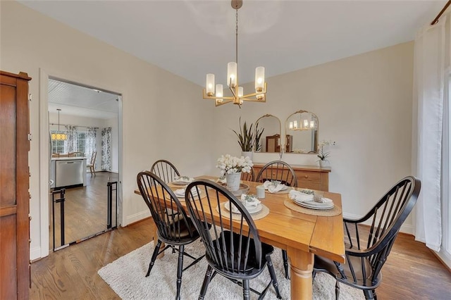 dining room with light wood-type flooring and an inviting chandelier