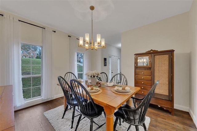 dining area featuring a healthy amount of sunlight, a notable chandelier, and hardwood / wood-style flooring