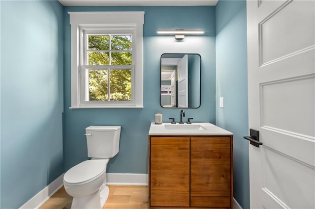 bathroom with vanity, toilet, and hardwood / wood-style floors