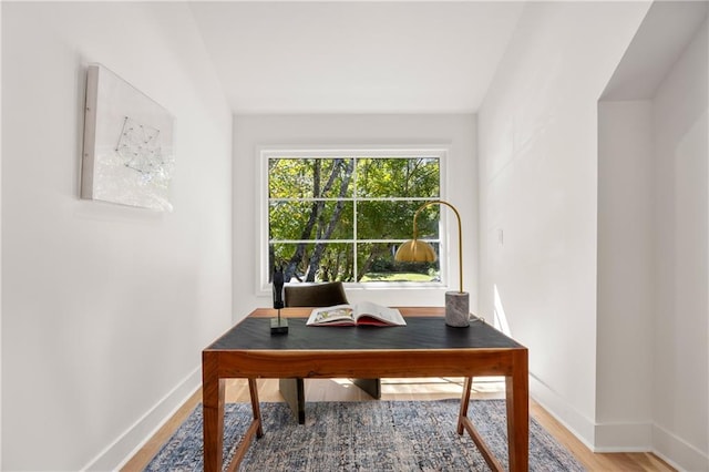 home office featuring lofted ceiling and hardwood / wood-style flooring