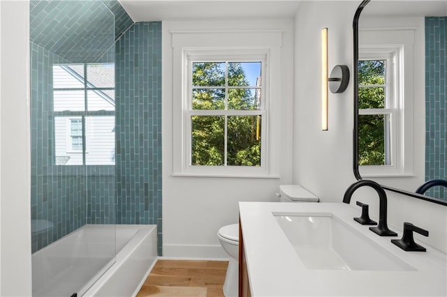 full bathroom featuring a healthy amount of sunlight, vanity, hardwood / wood-style floors, and toilet