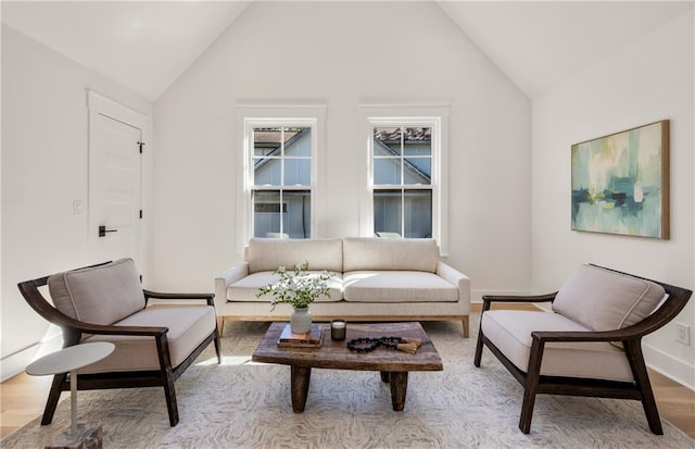 sitting room featuring high vaulted ceiling and light hardwood / wood-style floors