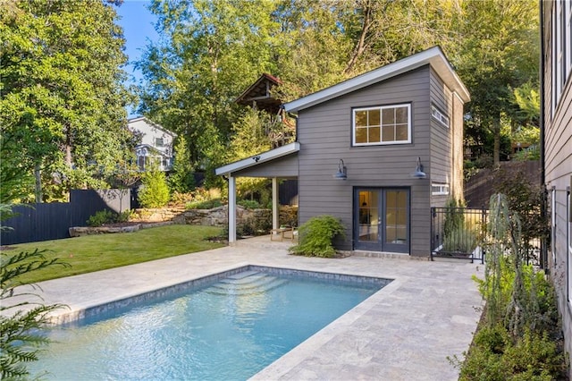 back of house featuring a fenced in pool, a patio area, and a yard