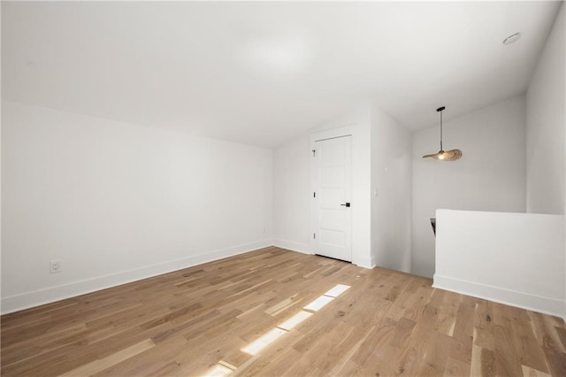 bonus room with vaulted ceiling and light wood-type flooring