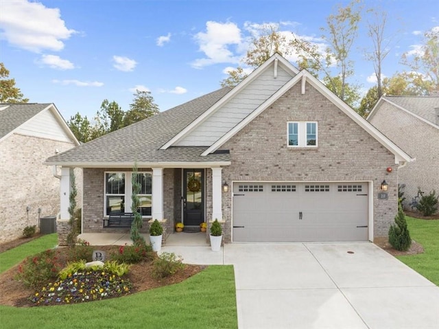 craftsman house with a garage, central air condition unit, and a front yard