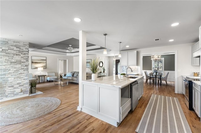 kitchen with visible vents, a sink, stainless steel dishwasher, wood finished floors, and black / electric stove