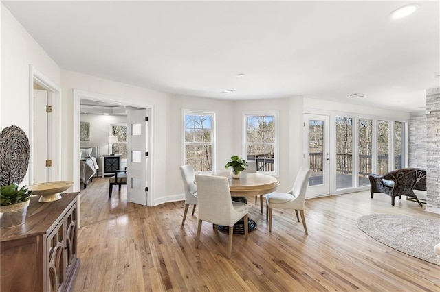 dining space featuring baseboards and light wood-type flooring