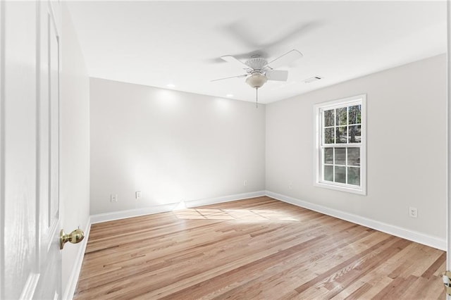 spare room featuring visible vents, a ceiling fan, light wood-type flooring, and baseboards