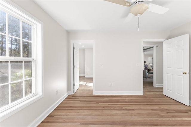 interior space with baseboards, light wood-type flooring, and ceiling fan
