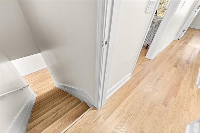 stairway featuring baseboards and wood finished floors