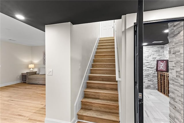 staircase featuring recessed lighting, wood finished floors, and baseboards