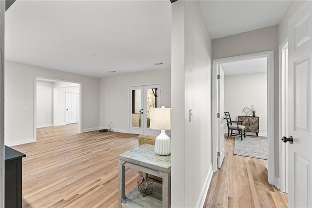 hallway with light wood-type flooring and baseboards