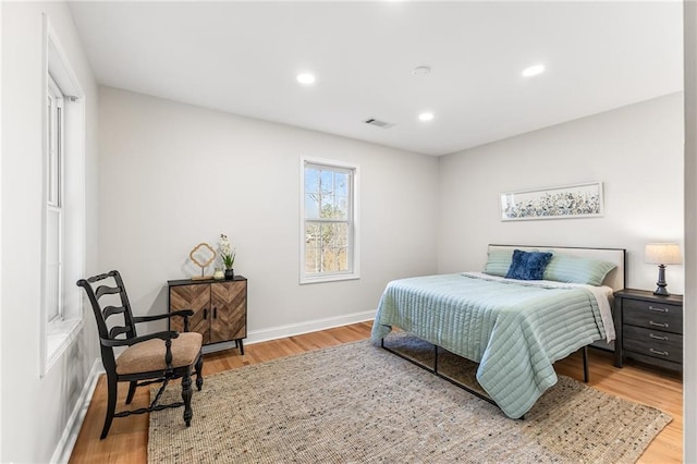 bedroom with recessed lighting, visible vents, baseboards, and wood finished floors