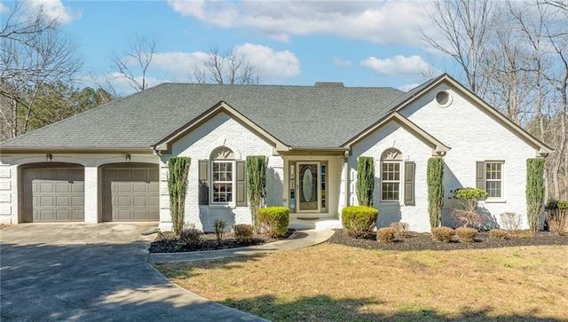 view of front of property featuring brick siding, a front lawn, concrete driveway, roof with shingles, and an attached garage