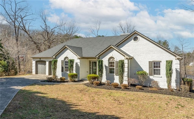 single story home with brick siding, an attached garage, concrete driveway, and a front lawn