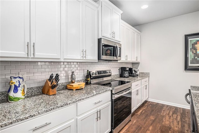 kitchen with dark wood finished floors, stainless steel appliances, tasteful backsplash, white cabinets, and light stone countertops