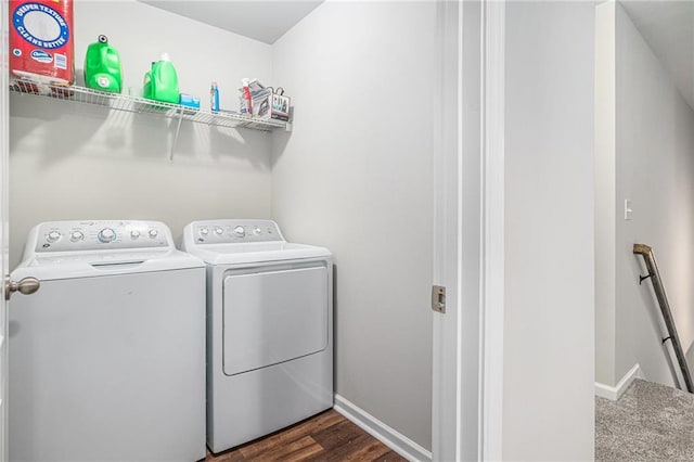 clothes washing area with laundry area, washer and clothes dryer, dark wood finished floors, and baseboards