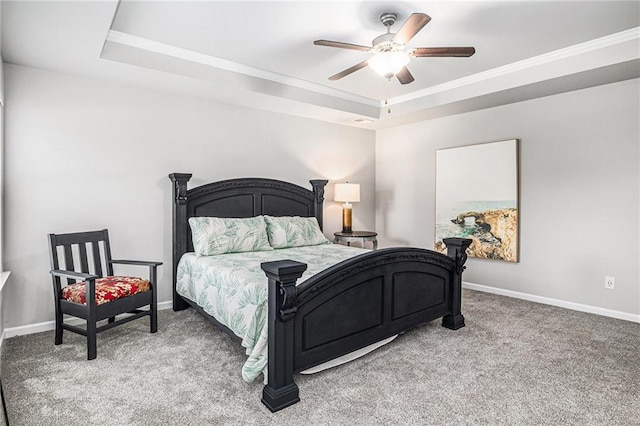 carpeted bedroom with a raised ceiling, crown molding, baseboards, and ceiling fan