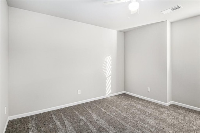 carpeted spare room featuring baseboards, visible vents, and a ceiling fan