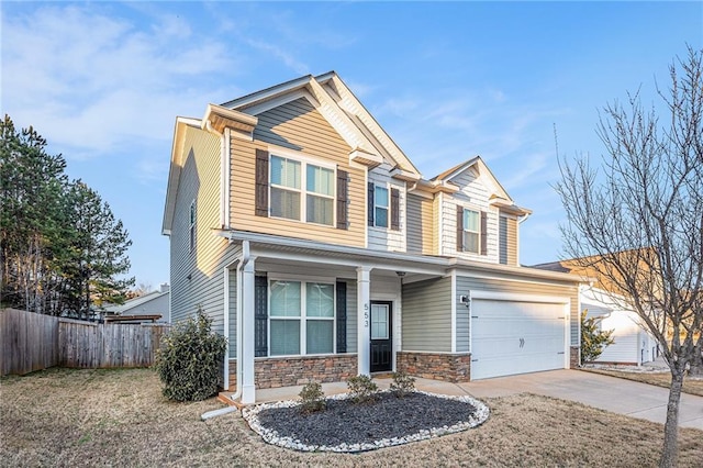 craftsman-style house featuring an attached garage, stone siding, fence, and concrete driveway
