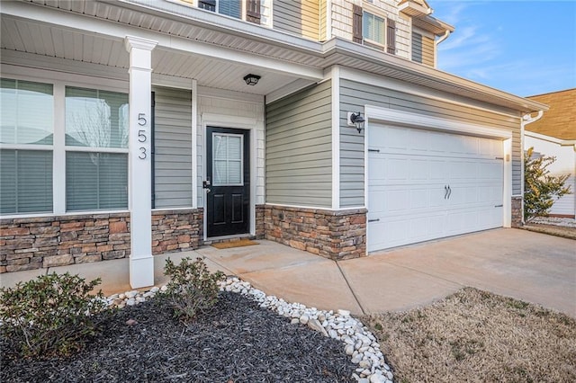 property entrance with an attached garage, stone siding, covered porch, and concrete driveway