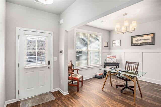 office space with a wainscoted wall, a chandelier, dark wood finished floors, and a decorative wall