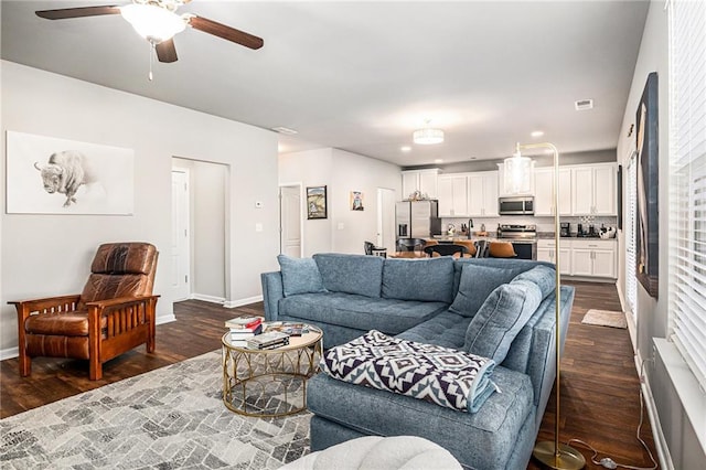 living room featuring recessed lighting, visible vents, a ceiling fan, baseboards, and dark wood-style floors