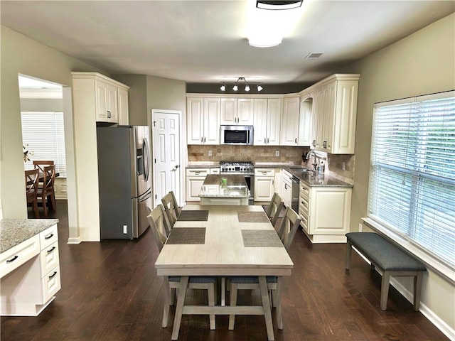 1015 Pebble Creek Trl, Suwanee, GA 30024 - kitchen featuring light stone counters, visible vents, decorative backsplash, appliances with stainless steel finishes, and dark wood-style flooring