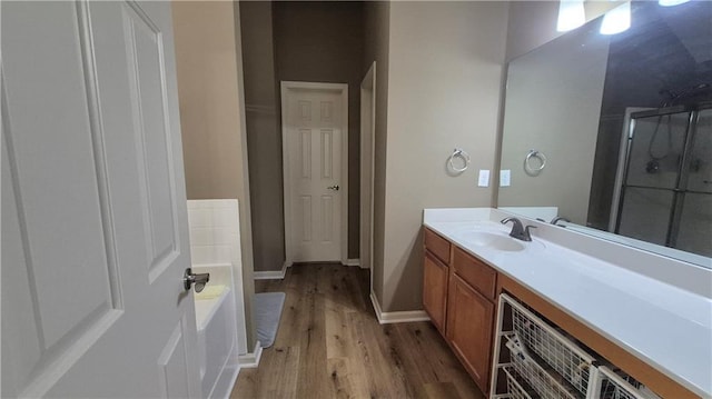 1015 Pebble Creek Trl, Suwanee, GA 30024 - bathroom with a shower with shower door, wood finished floors, vanity, a bath, and baseboards