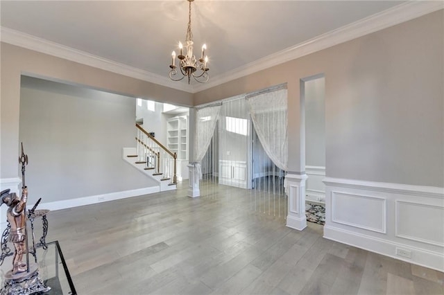 unfurnished room featuring stairway, wood finished floors, and crown molding