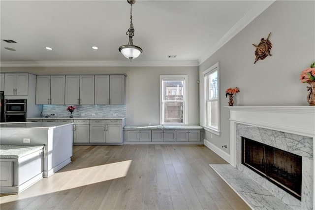 kitchen featuring gray cabinetry, visible vents, light countertops, backsplash, and crown molding