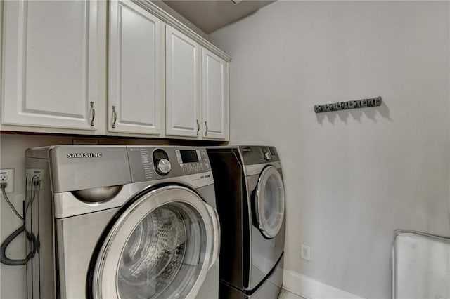 washroom featuring cabinet space and independent washer and dryer