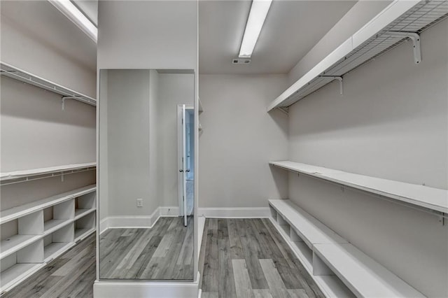 spacious closet featuring visible vents and wood finished floors