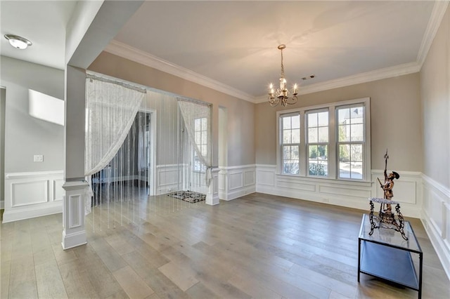 interior space featuring stairs, a notable chandelier, a decorative wall, and wood finished floors