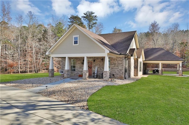 craftsman-style house with brick siding, covered porch, a shingled roof, and a front lawn