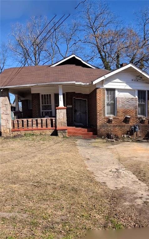 view of front of property with a porch and brick siding