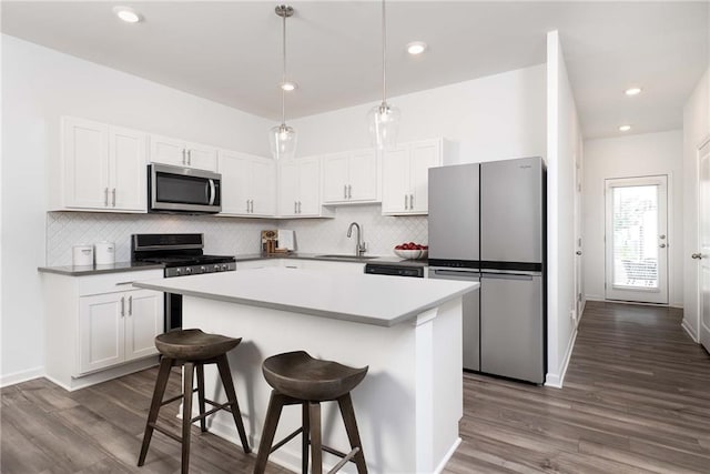 4428 Ryan St, Douglasville, GA 30135 - kitchen featuring stainless steel appliances, a sink, dark wood-style floors, tasteful backsplash, and white cabinets