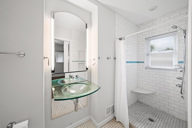bathroom featuring a shower stall, visible vents, and a sink