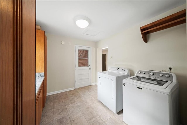 clothes washing area with attic access, baseboards, washing machine and clothes dryer, and laundry area