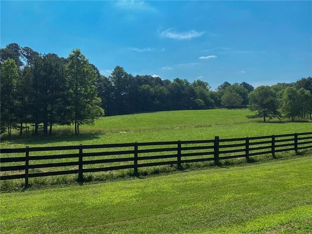 view of gate with a rural view and a lawn