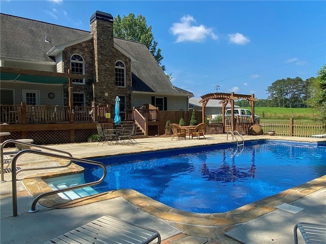 view of pool with a patio area, a wooden deck, and a pergola