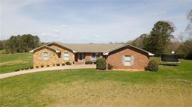 single story home with a trampoline and a front lawn