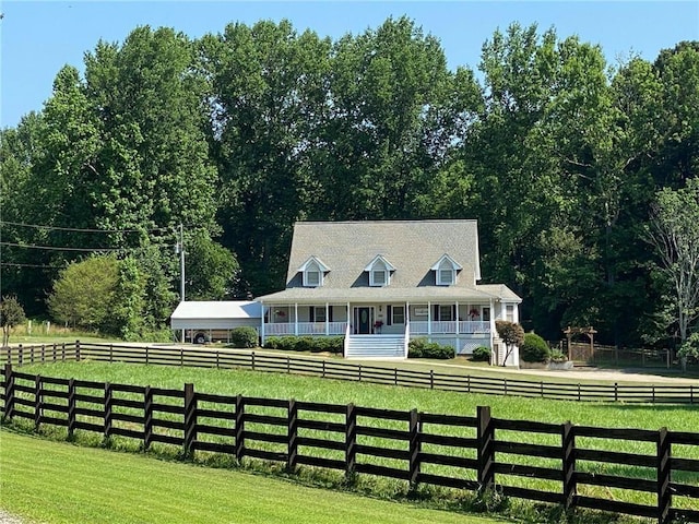 view of front facade featuring a front yard, a rural view, and a porch