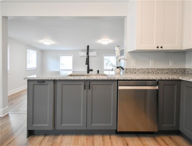 kitchen with light stone countertops, appliances with stainless steel finishes, light wood-type flooring, gray cabinetry, and white cabinetry